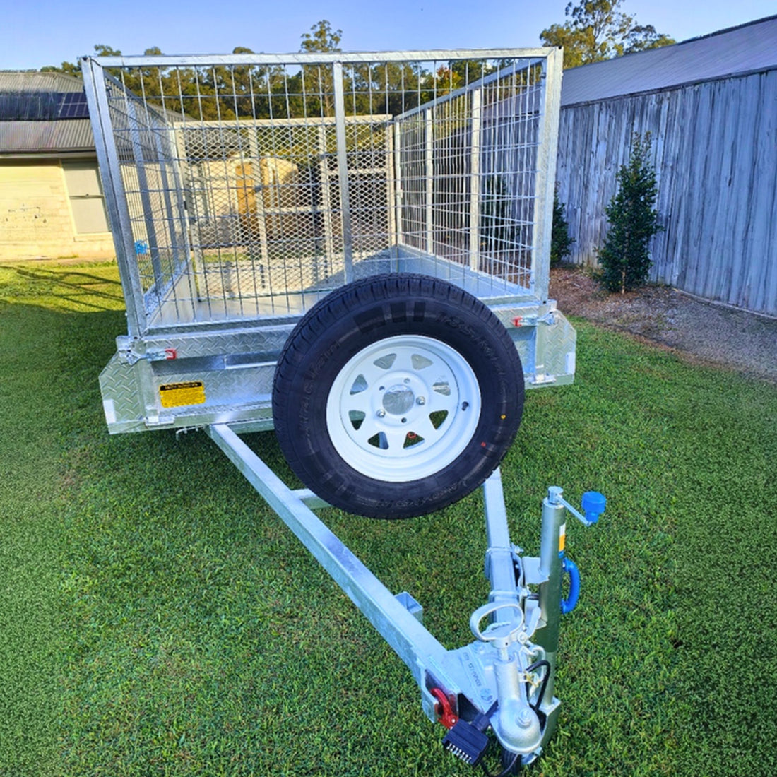 cage trailer hire Brisbane​ - Small trailer with a metal cage on a white background