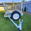 cage trailer hire Brisbane​ - Small trailer with a wire cage on a grassy area