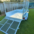 cage trailer hire Brisbane​ - Metal utility trailer with a grid floor on grass