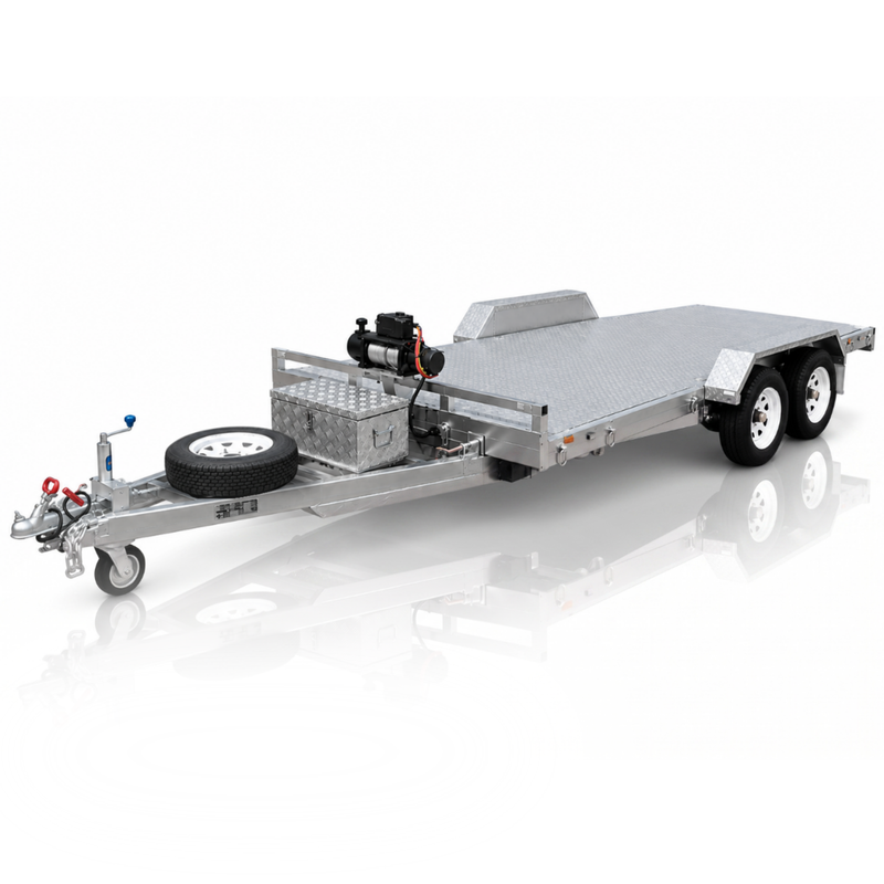 A silver aluminum flatbed car trailer with a diamond plate deck, dual rear wheels, a front hitch, a spare tire mounted on the tongue, and a small engine and storage box on the bed, shown on a white reflective studio background.