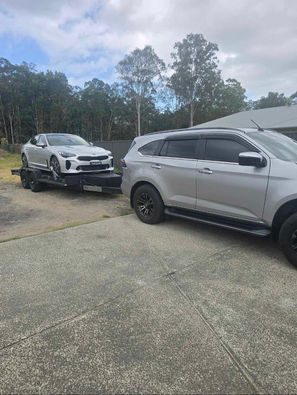 silver car on heavy-duty car trailer hire for vehicle relocation